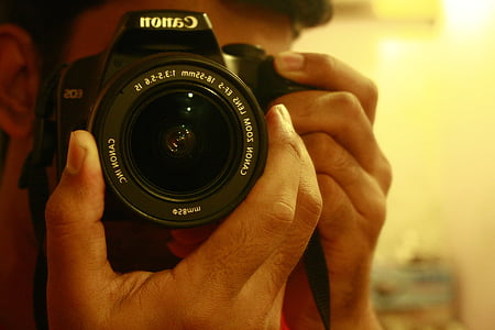 man aiming Canon DSLR camera photography thumbnail