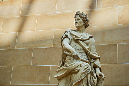 beige concrete statue near wall thumbnail