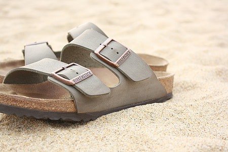 pair of flip-flops on sand thumbnail
