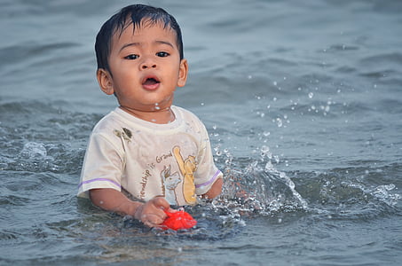 boy swimming on body of water during daytime thumbnail