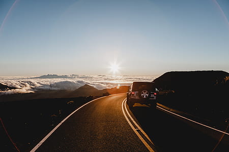 white Jeep Wrangler SUV on road during golden hour thumbnail