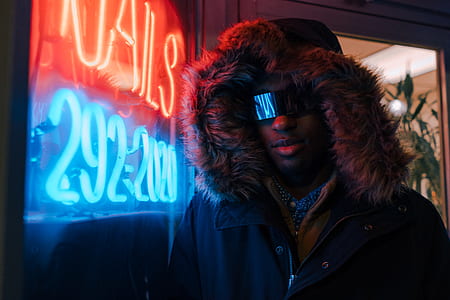 man standing near turned on neon signage thumbnail