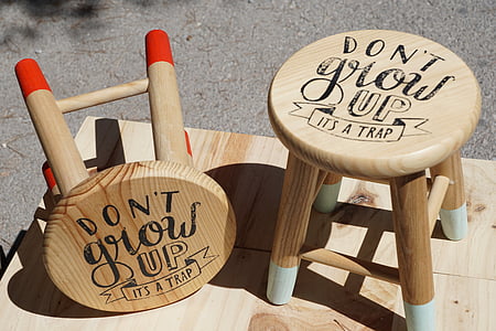 two round beige don't grow up-printed wooden stools on beige wooden board thumbnail