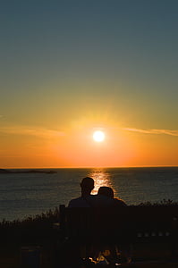 silhouette of man and woman looking at sunset thumbnail
