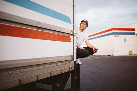 man riding at the back of delivery truck thumbnail