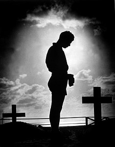 silhouette of man standing beside cross thumbnail
