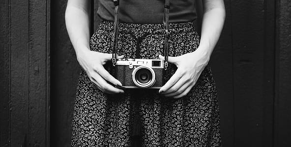 Monochrome Photo of Person Holding Vintage Camera thumbnail