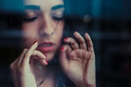 woman standing in front of glass with closed eyes thumbnail