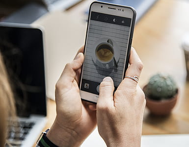 person's holding smartphone displaying camera thumbnail