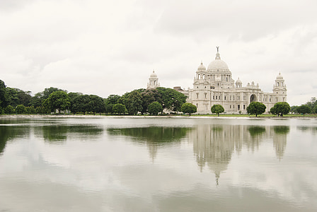 gray mosque near body of water and trees thumbnail