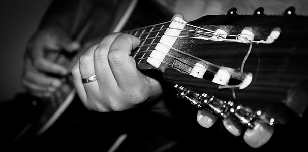 human performing acoustic guitar grayscale photo thumbnail