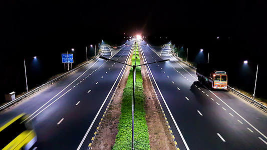 orange bus at highway photography during nighttime thumbnail