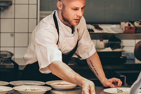 man in chef uniform serving foods thumbnail