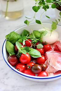 bunch of round red fruits on white ceramic bowl thumbnail