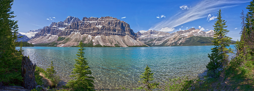 blue sea near grey rocky mountains under white and blue sky thumbnail