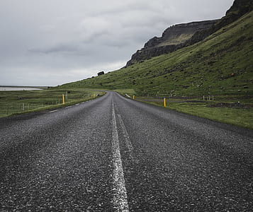 asphalt road near mountain during daytime thumbnail