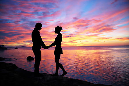 silhouette of man and woman near body of water thumbnail