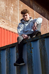 man sitting on intermodal container ledge at daytime thumbnail