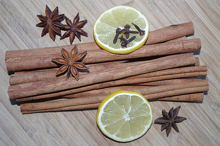 cinnamon sticks and anis star with slices of lemons on surface thumbnail