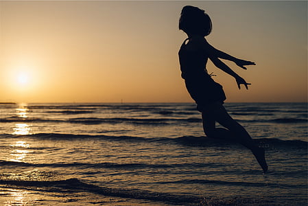 woman jumping in mid air in seashore thumbnail