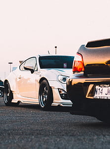 photo of white coupe near black car thumbnail
