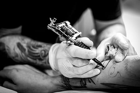 person using tattoo machine on arm thumbnail
