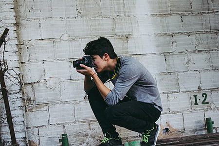 man taking photo of black pole thumbnail