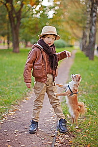 boy standing on pathway in between of green grass thumbnail