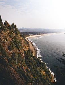 high-angle photography of hill beside body of water at daytime thumbnail