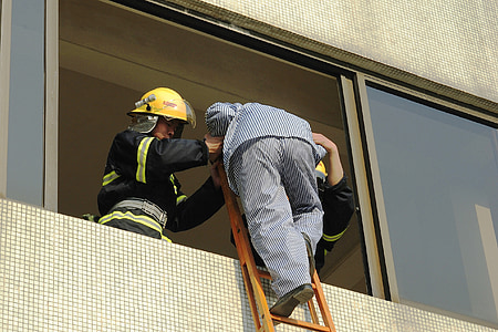 firefighter beside man climbing ladder thumbnail