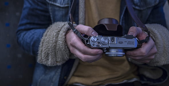 person holding gray camera thumbnail