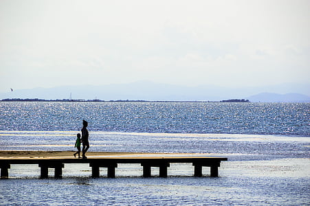 woman with child standing on dock thumbnail