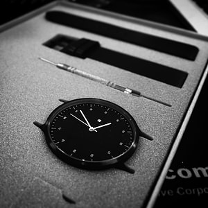 round black analog watch pointing at 4:06 thumbnail