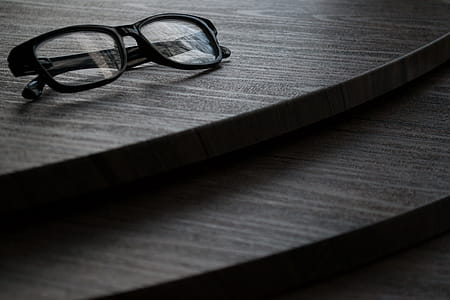 Black Framed Eyeglasses on Brown Surface thumbnail