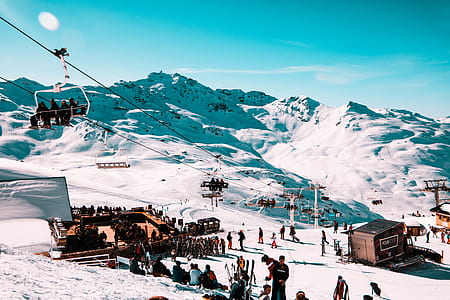 people on snow near mountains near brown house at daytime thumbnail