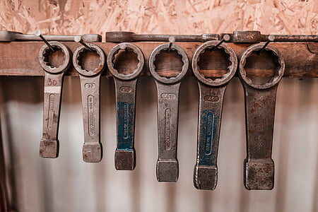 six gray metal wrenches on hooks thumbnail