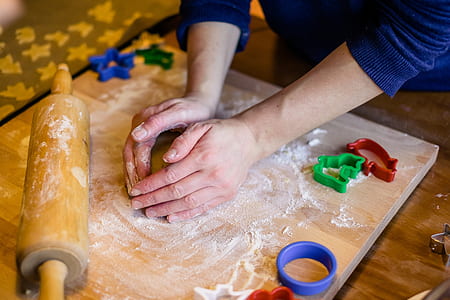 person kneading dough on brown wooden chopping board thumbnail