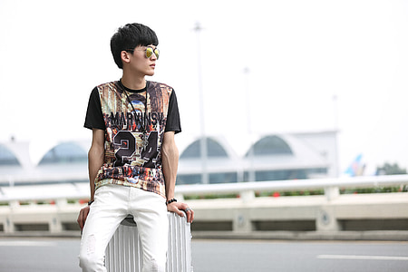 man sitting on white concrete post thumbnail