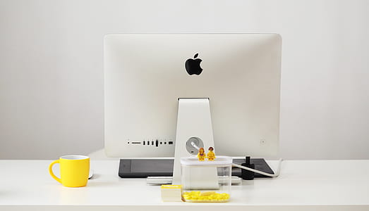 silver iMac on white table beside yellow mug thumbnail