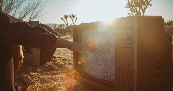 person touching vintage gray TV at daytime thumbnail