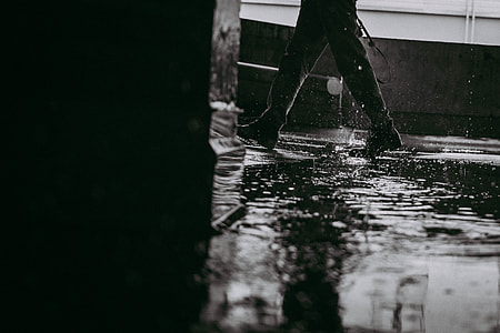grayscale photo of person walking on pathway with water thumbnail