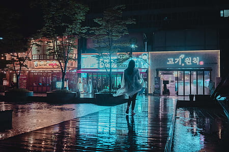 woman walking under the rain wearing raincoat thumbnail