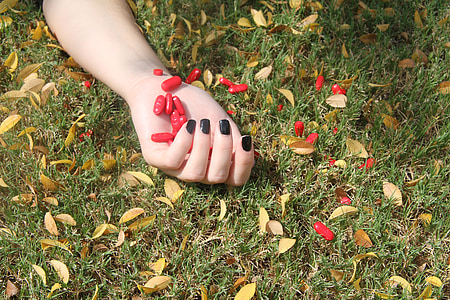 person's hand with red pills thumbnail