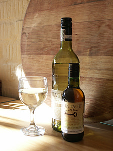 wine glass beside two wine bottles thumbnail