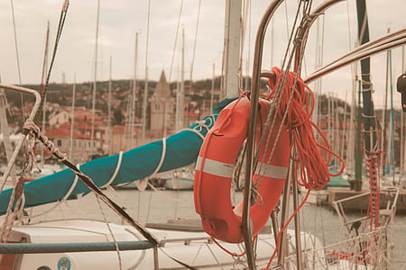 orange and gray swim ring hanged on boat taken during daytime thumbnail
