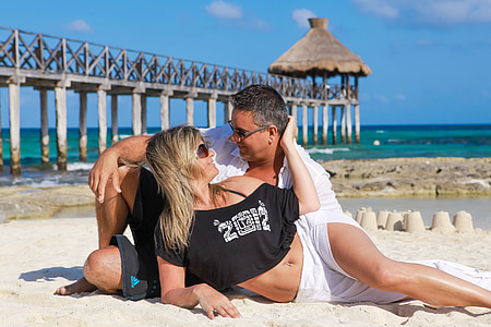 woman and man laying on white sand thumbnail