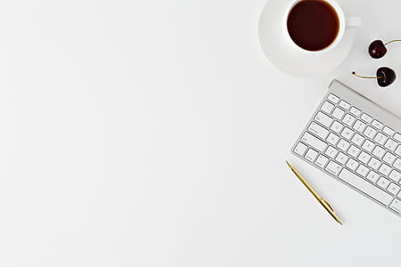 Apple Wireless Keyboard near on coffee mug and retractable pen thumbnail