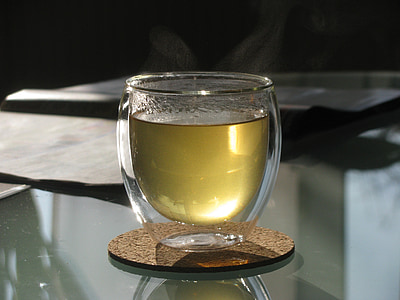 yellow liquid filled clear rock glass on brown coaster thumbnail