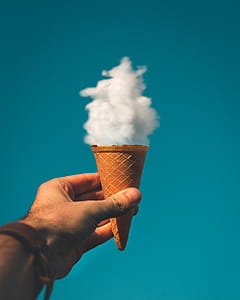 Man Holding Ice Cream Cone Under Cloud thumbnail