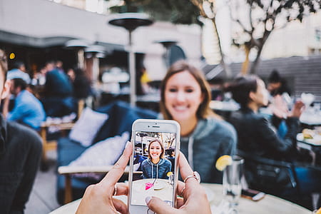 selective focus photo of person taking a photo of woman thumbnail